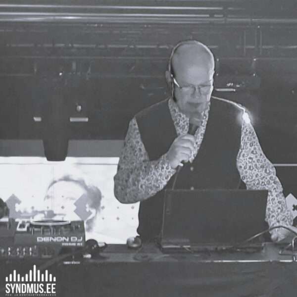 VJ Einar Kass esinemas retrovideodiskol koos ekraanil olevate muusikavideotega