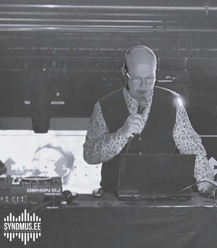 VJ Einar Kass esinemas retrovideodiskol koos ekraanil olevate muusikavideotega